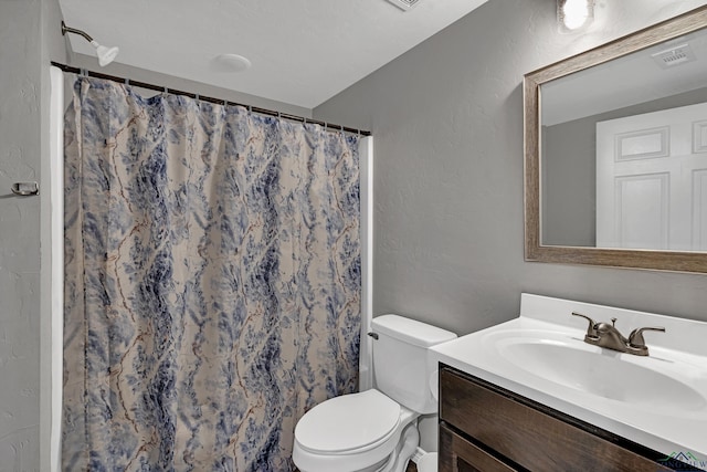 bathroom featuring vanity, toilet, and curtained shower