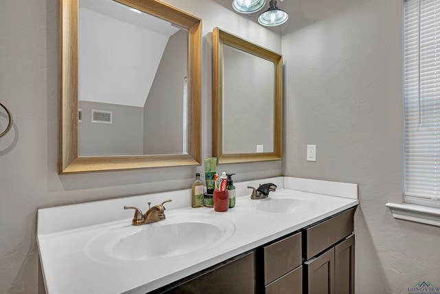 bathroom with vanity and lofted ceiling