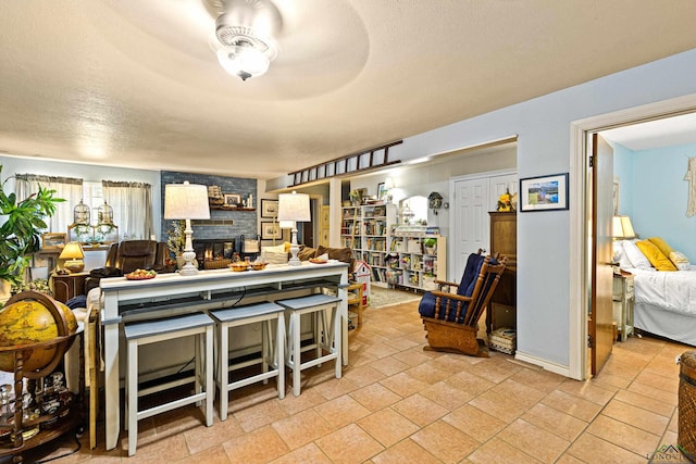 kitchen with a large fireplace, a textured ceiling, and ceiling fan