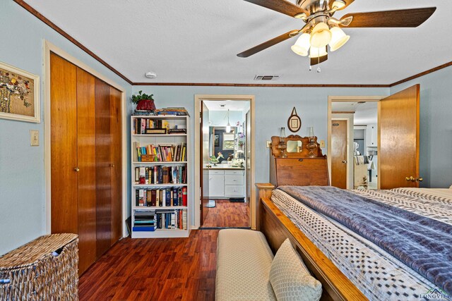 bedroom featuring dark hardwood / wood-style flooring, connected bathroom, crown molding, and a closet