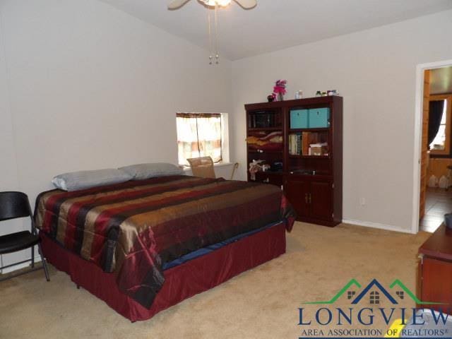 carpeted bedroom with vaulted ceiling and ceiling fan