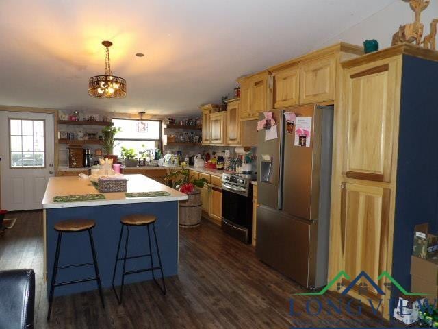 kitchen with a center island, dark hardwood / wood-style flooring, hanging light fixtures, and appliances with stainless steel finishes