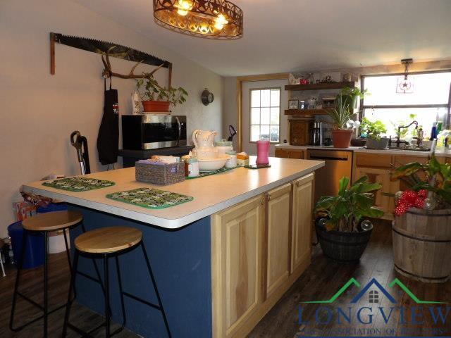 kitchen featuring a breakfast bar, stainless steel appliances, dark wood-type flooring, sink, and a kitchen island