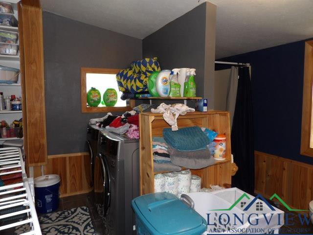 laundry room featuring washer and dryer and wooden walls