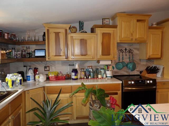 kitchen with tasteful backsplash, black range with electric stovetop, and sink