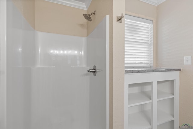 bathroom featuring ornamental molding and a shower