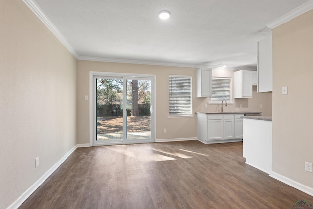 unfurnished living room featuring dark wood-type flooring, plenty of natural light, and crown molding