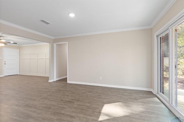 spare room with plenty of natural light, wood finished floors, visible vents, and crown molding