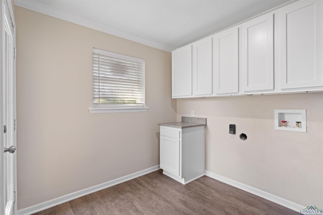 clothes washing area with cabinet space, baseboards, wood finished floors, hookup for a washing machine, and crown molding