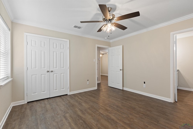 unfurnished bedroom with dark wood-style floors, multiple windows, visible vents, and a closet