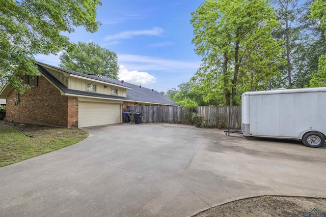 3 Ramblewood Dr, Longview, TX 75605 - view of side of property with brick siding, driveway, board and batten siding, and a garage