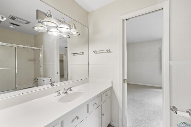 3 Ramblewood Dr, Longview, TX 75605 - full bathroom featuring vanity, bath / shower combo with glass door, wainscoting, and toilet