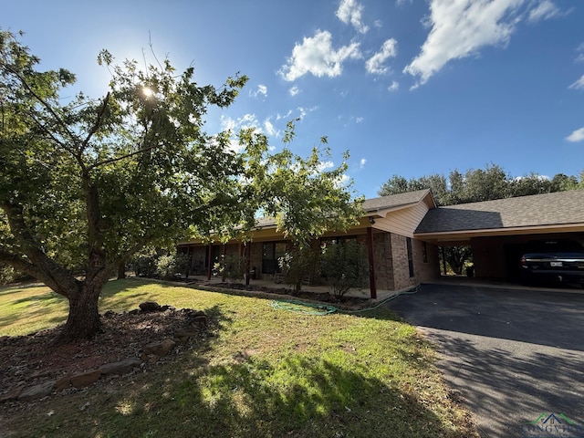 view of front of house with a carport and a front lawn