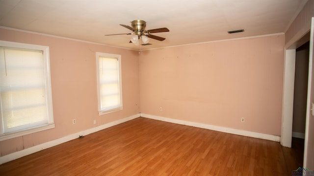 spare room featuring hardwood / wood-style floors, ceiling fan, and crown molding