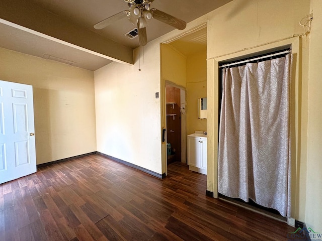 spare room with beamed ceiling, dark hardwood / wood-style floors, and ceiling fan