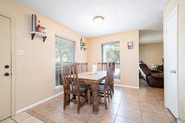 dining area with light tile patterned floors and a textured ceiling