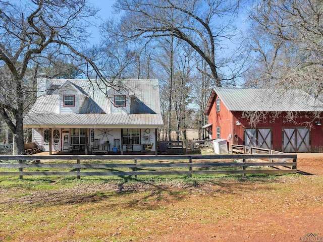 back of house with a porch and an outdoor structure