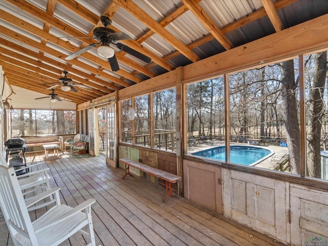 unfurnished sunroom with ceiling fan and lofted ceiling