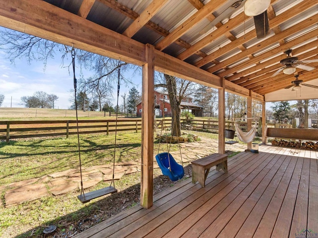 wooden deck featuring ceiling fan, a yard, and a rural view