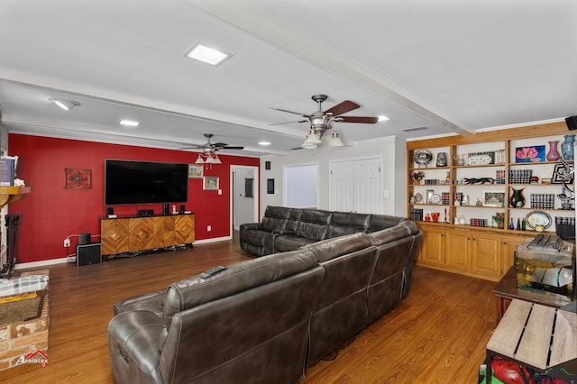 living room with built in shelves, beamed ceiling, and hardwood / wood-style flooring