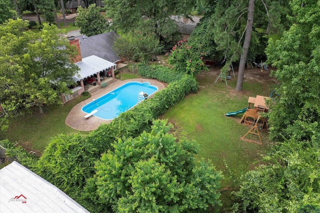 view of swimming pool featuring a playground, a diving board, a lawn, and a deck