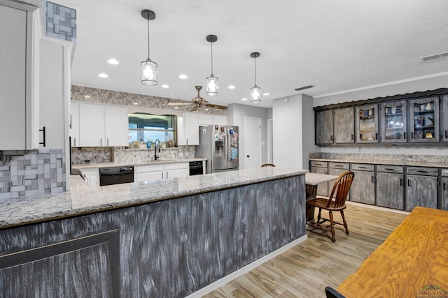 3955 E US Highway 79, Henderson, TX 75652 - kitchen with stainless steel fridge with ice dispenser, black dishwasher, a sink, light wood-style flooring, and backsplash