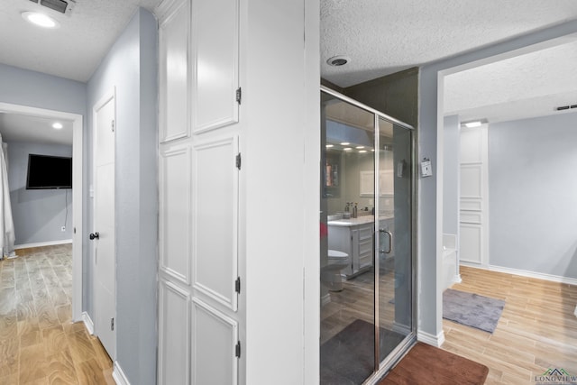 3955 E US Highway 79, Henderson, TX 75652 - corridor featuring light wood finished floors, a textured ceiling, baseboards, and recessed lighting