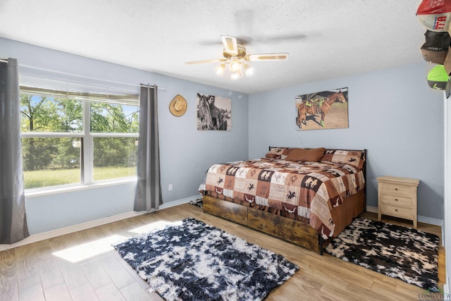3955 E US Highway 79, Henderson, TX 75652 - bedroom featuring wood finished floors, baseboards, a ceiling fan, and a textured ceiling