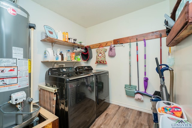 washroom with gas water heater, washing machine and dryer, and light hardwood / wood-style floors