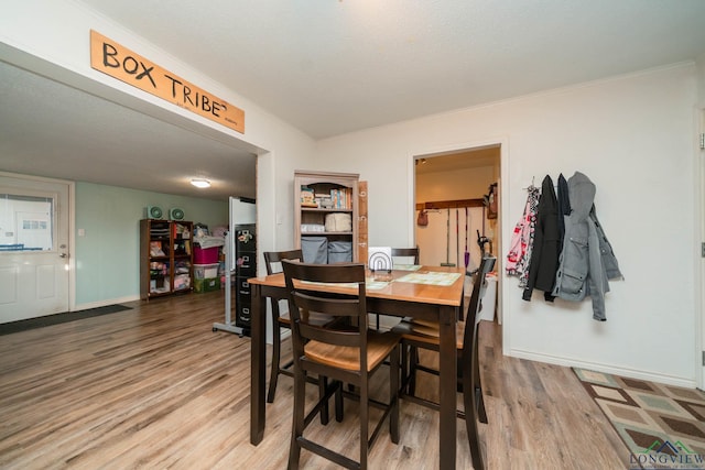 dining space featuring crown molding and wood-type flooring