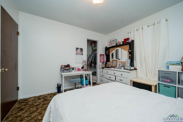 carpeted bedroom featuring a walk in closet, a textured ceiling, and a closet