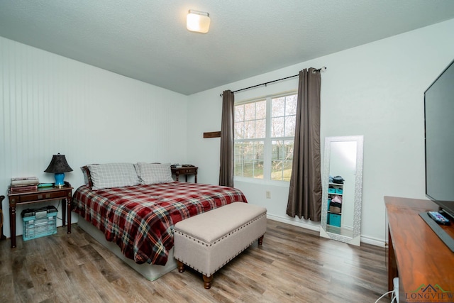 bedroom with a textured ceiling and hardwood / wood-style flooring