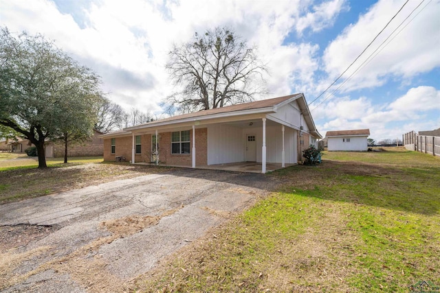 ranch-style house with a carport and a front lawn