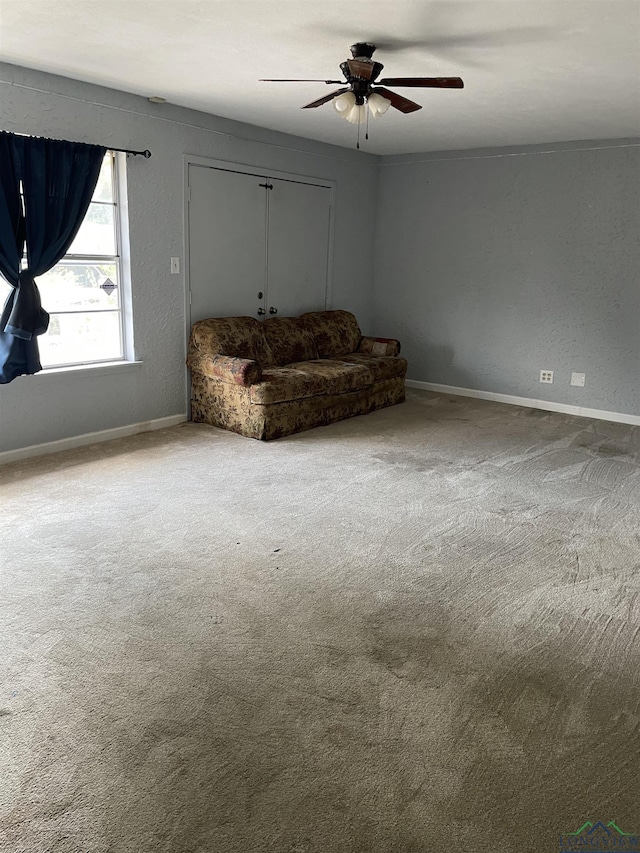 unfurnished room featuring ceiling fan and carpet flooring