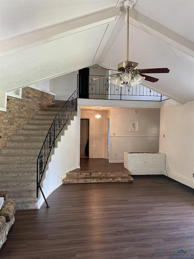 unfurnished living room featuring dark hardwood / wood-style flooring, beam ceiling, high vaulted ceiling, and ceiling fan