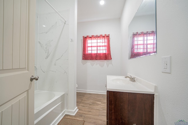 full bathroom with vanity, toilet, wood-type flooring, and tiled shower / bath