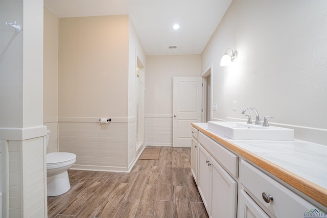 bathroom featuring hardwood / wood-style flooring, vanity, and toilet