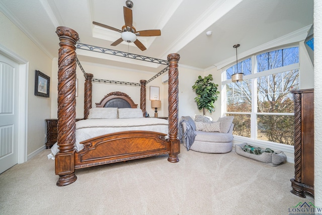 carpeted bedroom featuring a tray ceiling, crown molding, and ceiling fan