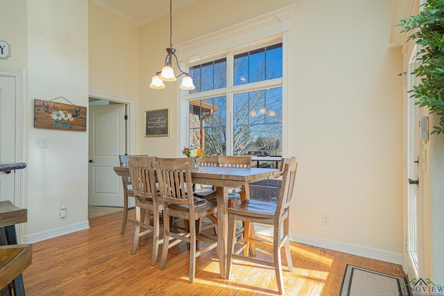 dining space with crown molding, a chandelier, and light hardwood / wood-style floors