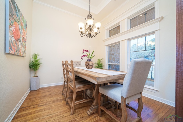 dining area featuring wood-type flooring, a healthy amount of sunlight, and a chandelier