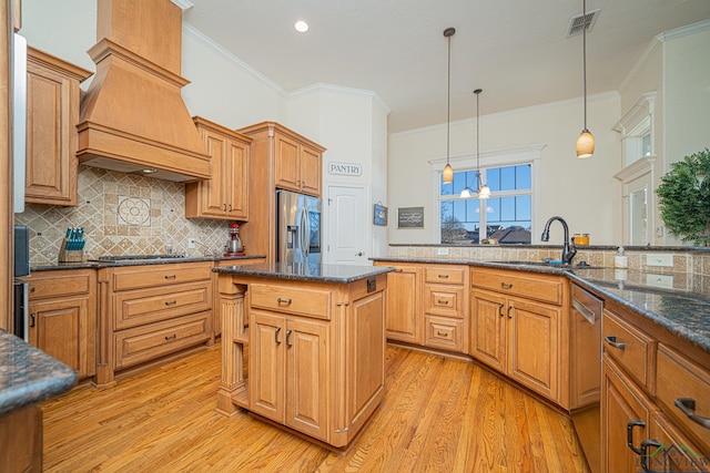 kitchen featuring sink, premium range hood, appliances with stainless steel finishes, backsplash, and a kitchen island