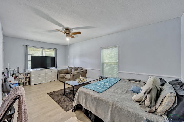 212 W W Ctr, White Oak, TX 75693 - bedroom with light wood-type flooring, a textured ceiling, and a ceiling fan