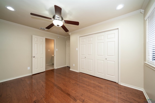 unfurnished bedroom with ceiling fan, ornamental molding, dark hardwood / wood-style flooring, and a closet