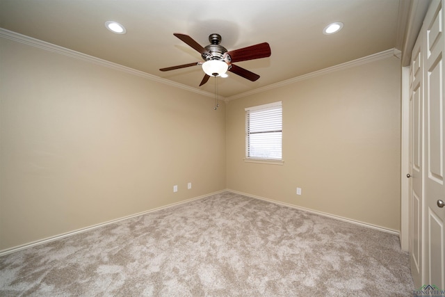 carpeted spare room with crown molding and ceiling fan