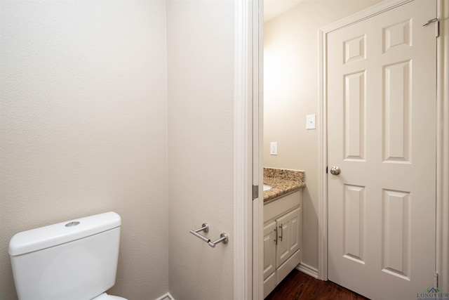 bathroom with vanity, wood-type flooring, and toilet