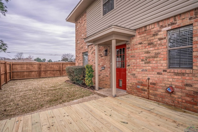 wooden deck featuring a lawn