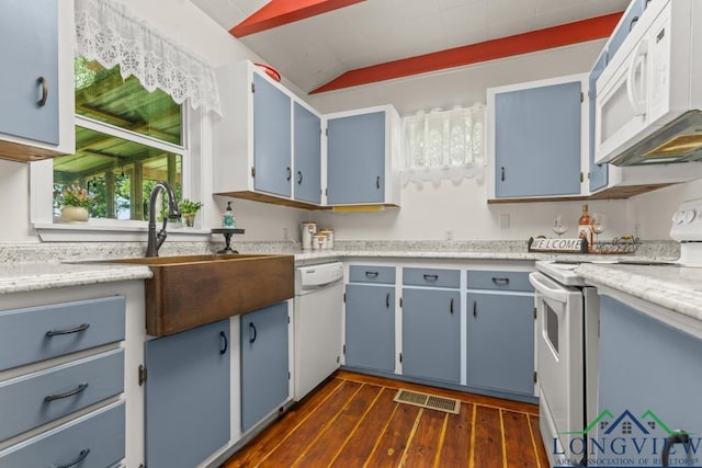 263 Crestwood Loop, Avinger, TX 75630 - kitchen with white appliances, blue cabinetry, dark wood finished floors, vaulted ceiling, and light countertops