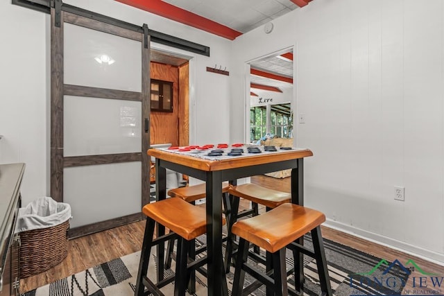 263 Crestwood Loop, Avinger, TX 75630 - dining area featuring a barn door and wood finished floors
