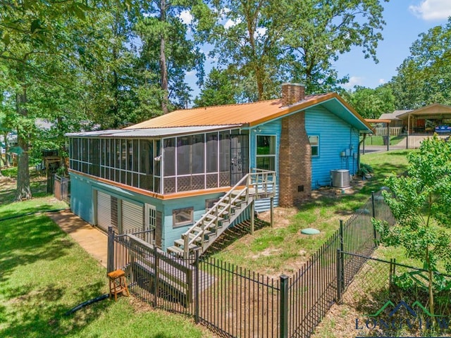 263 Crestwood Loop, Avinger, TX 75630 - rear view of house featuring a sunroom, a chimney, a garage, and a fenced backyard