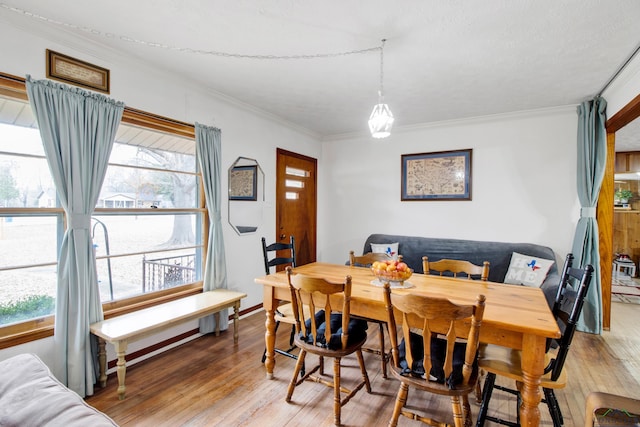 dining room featuring hardwood / wood-style floors, crown molding, and a wealth of natural light